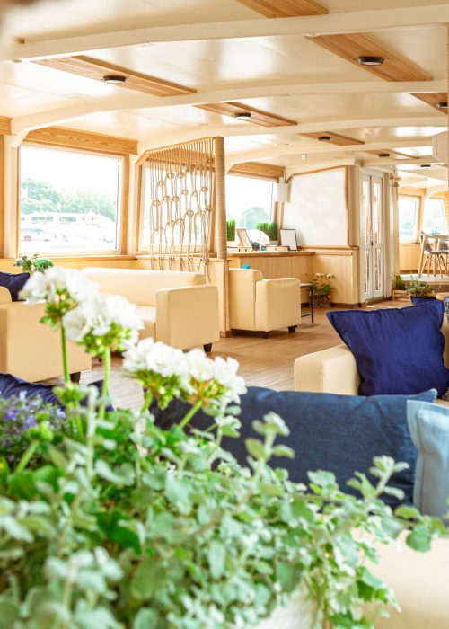 The interior of the urban river ship, with a panoramic view of the urban landscape. The concept of tourism, recreation, walking around the city, rest in the city. River transport